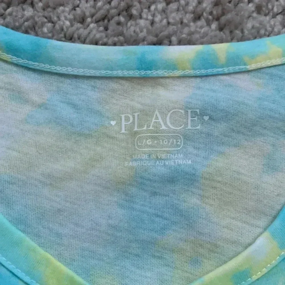 Girls tie dye shirt with cute detail on the bottom right part of the shirt